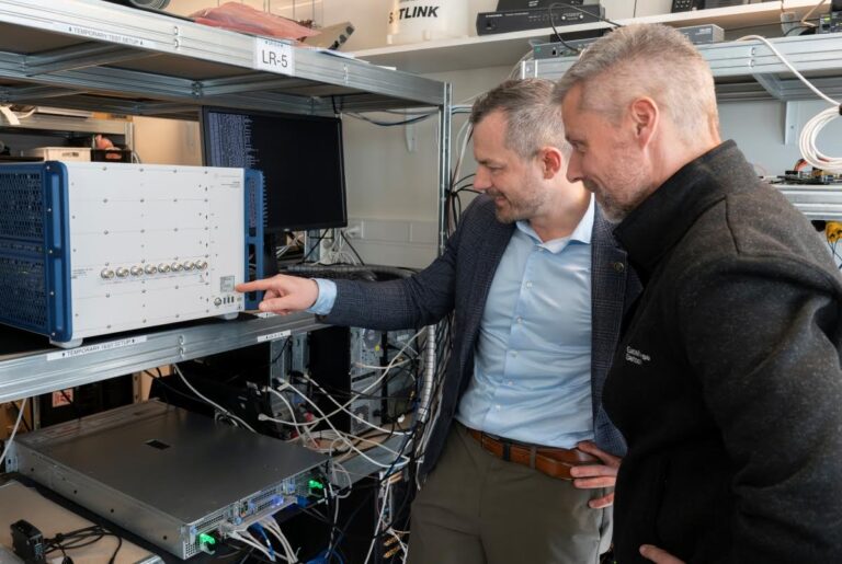 Peter Mariager (right), VP 5G Technology at Gatehouse Satcom, and Kristian Hausgaard Ulstrup, Technical Manager from R&S, pictured with the CMX500 test unit. Credit: Gatehouse Satcom